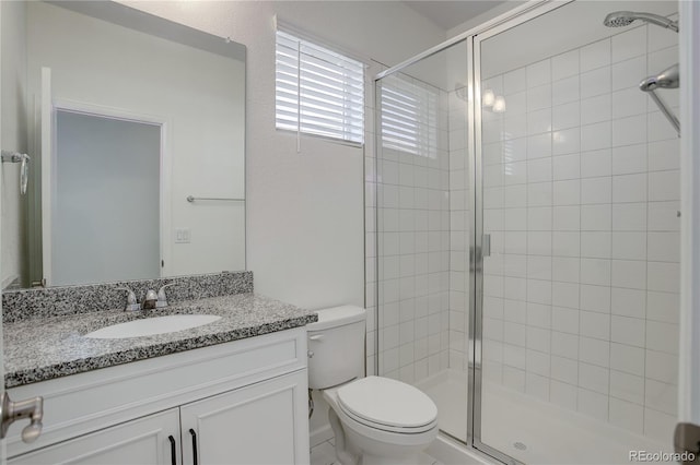 bathroom featuring vanity, toilet, and a shower with shower door