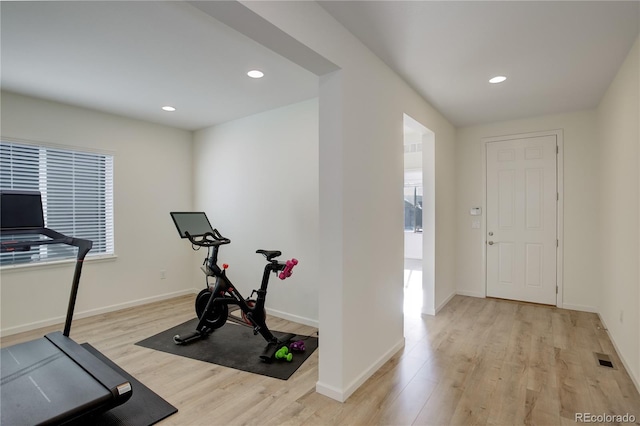 exercise room with light hardwood / wood-style floors