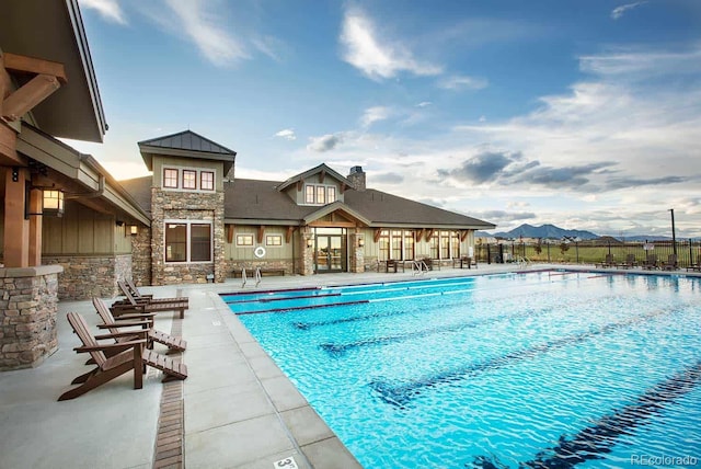 view of swimming pool with a patio and a mountain view