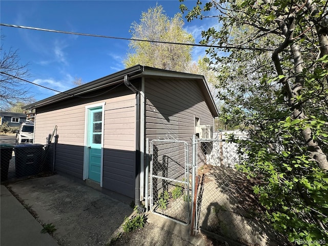 view of side of home featuring fence and a gate