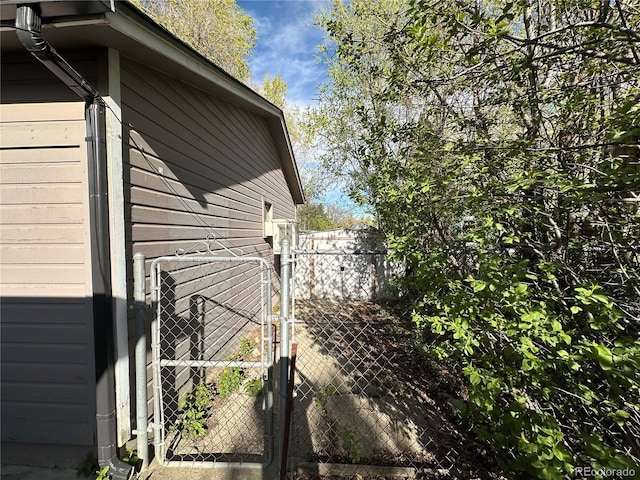 view of property exterior with fence and a gate