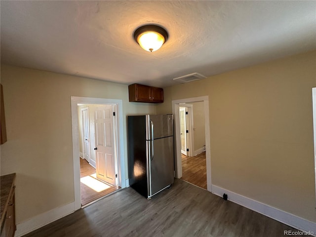 kitchen featuring baseboards, freestanding refrigerator, and dark wood finished floors