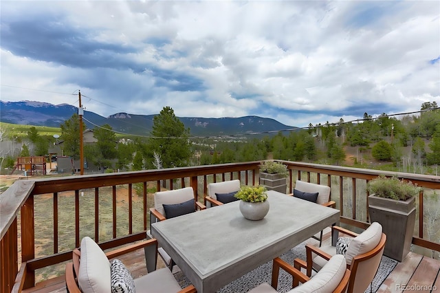 deck featuring a mountain view and outdoor dining area