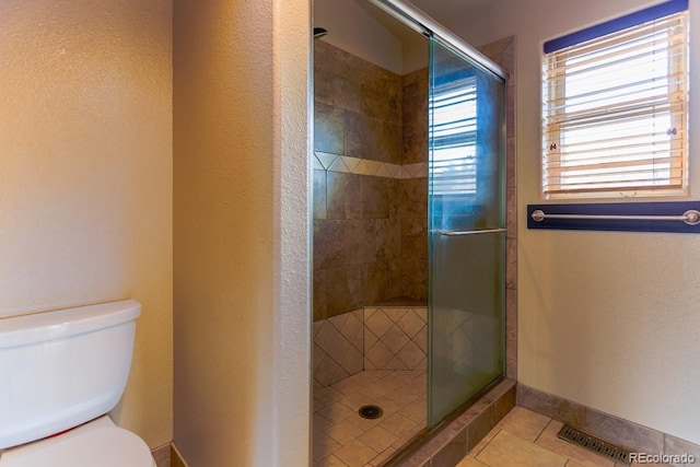 full bathroom featuring a shower stall, toilet, visible vents, and tile patterned floors