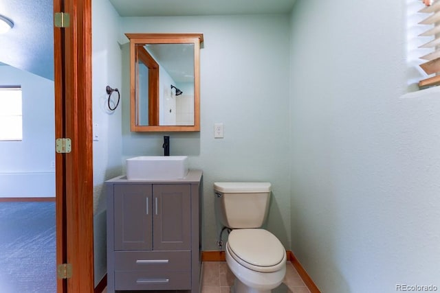 bathroom featuring tile patterned floors, baseboards, toilet, and vanity