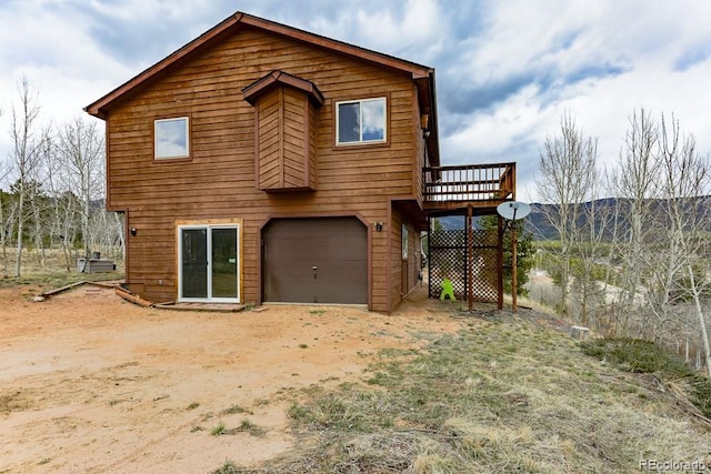 view of front of property with driveway, a deck, and an attached garage