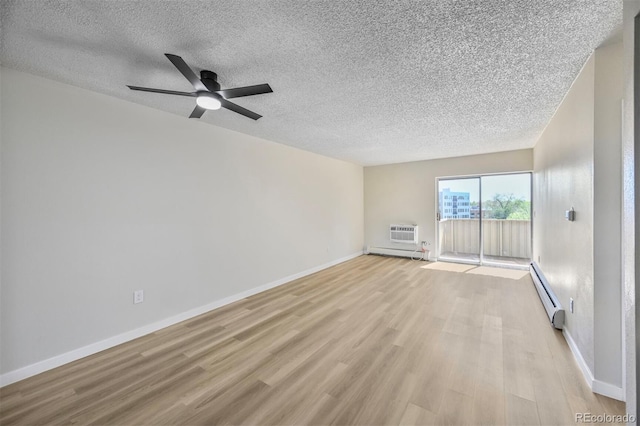 empty room with a baseboard heating unit, a textured ceiling, light wood finished floors, ceiling fan, and baseboards