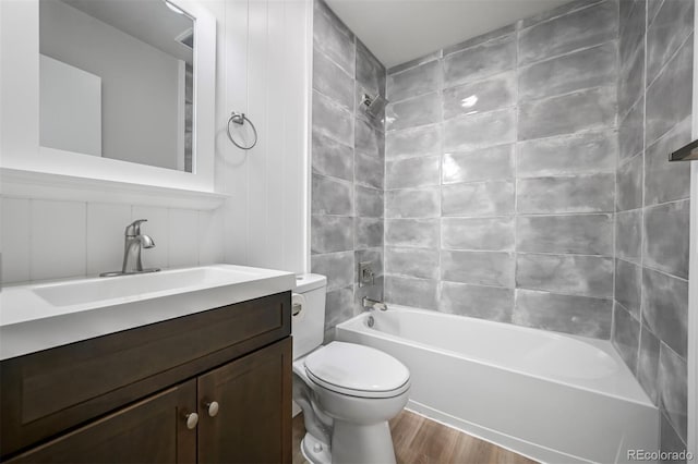 bathroom with toilet, wood finished floors, shower / bath combination, and vanity