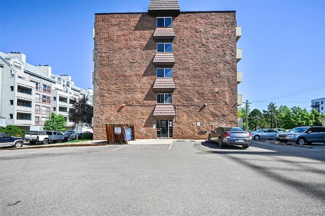 view of apartment building / complex with uncovered parking