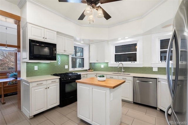 kitchen featuring wood counters, sink, black appliances, a center island, and white cabinets