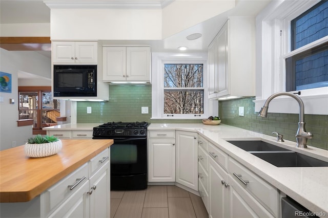 kitchen with white cabinetry, sink, butcher block countertops, and black appliances