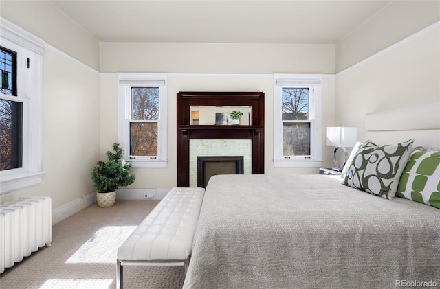 bedroom with light colored carpet, radiator, and multiple windows