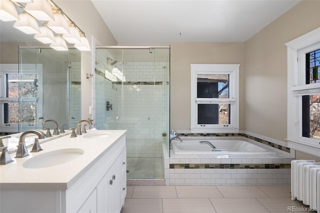 bathroom with independent shower and bath, vanity, tile patterned flooring, and radiator heating unit