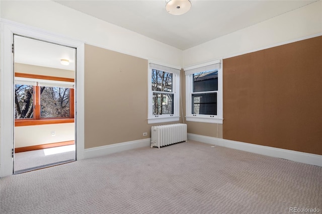 empty room with radiator heating unit and light colored carpet