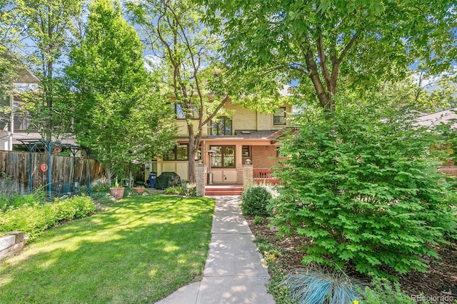 view of property hidden behind natural elements featuring a front yard