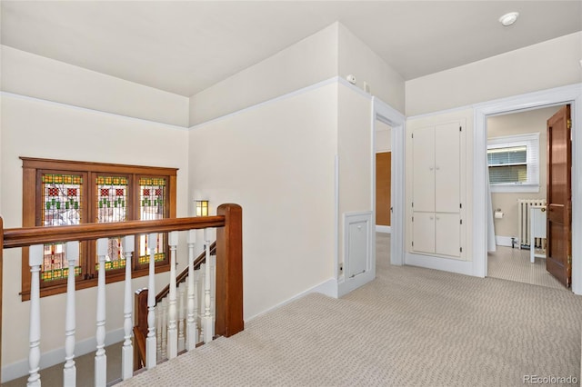 corridor featuring radiator and light carpet