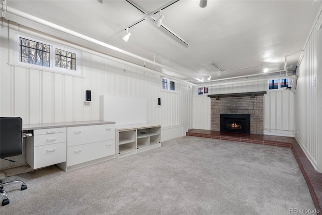 interior space featuring light colored carpet, a fireplace, and rail lighting