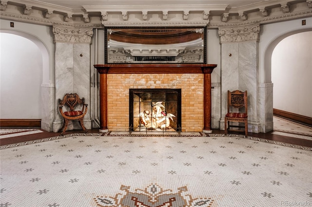 unfurnished living room with ornamental molding and a tiled fireplace