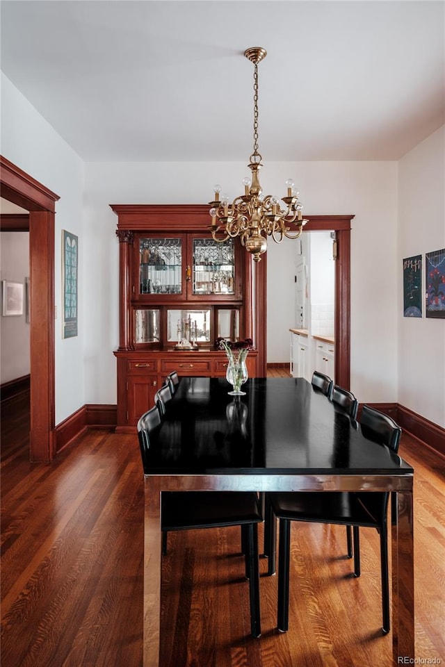 dining room featuring wood-type flooring and an inviting chandelier