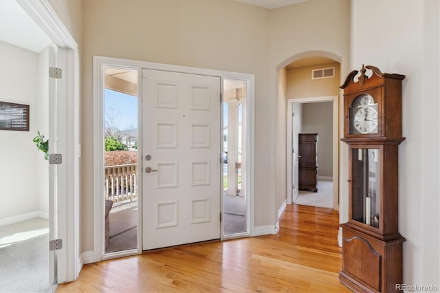 8714 E 148th Cir, Thornton, CO 80602 - entrance foyer with light wood-style flooring, visible vents, a wealth of natural light, and arched walkways