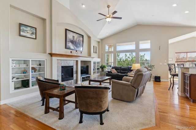8714 E 148th Cir, Thornton, CO 80602 - living area featuring a tiled fireplace, a wealth of natural light, a ceiling fan, and light wood finished floors