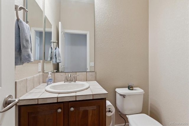 8714 E 148th Cir, Thornton, CO 80602 - bathroom featuring toilet, a textured wall, and vanity