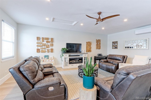 living area with ceiling fan, light wood-style flooring, recessed lighting, an AC wall unit, and attic access