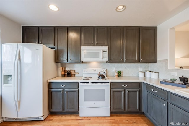 kitchen with white appliances, light hardwood / wood-style floors, and dark brown cabinetry