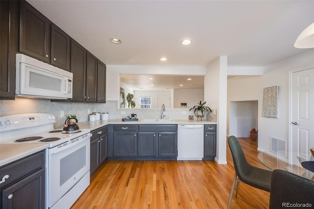 kitchen featuring white appliances, light hardwood / wood-style floors, backsplash, and sink