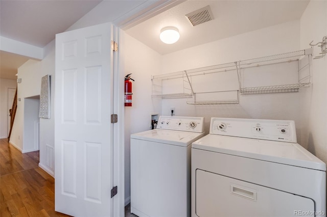 washroom with separate washer and dryer and hardwood / wood-style floors