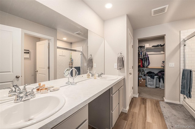 bathroom featuring an enclosed shower, vanity, and hardwood / wood-style flooring