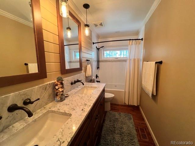85 S Sherwood Gln, Monument, CO 80132 - full bathroom with ornamental molding, double vanity, baseboards, shower / bath combo, and toilet