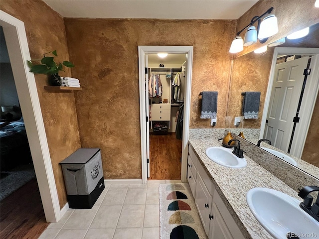 85 S Sherwood Gln, Monument, CO 80132 - bathroom with double vanity, a walk in closet, tile patterned floors, and baseboards
