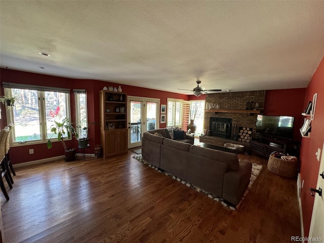 85 S Sherwood Gln, Monument, CO 80132 - living area featuring a fireplace, wood finished floors, a ceiling fan, a textured ceiling, and baseboards