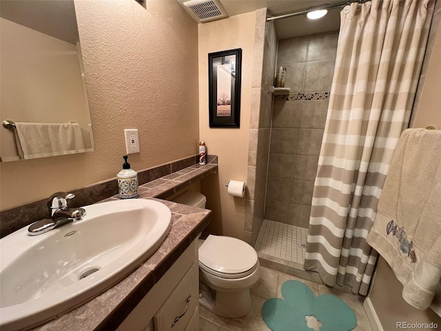 85 S Sherwood Gln, Monument, CO 80132 - bathroom with toilet, a tile shower, vanity, a textured wall, and tile patterned floors