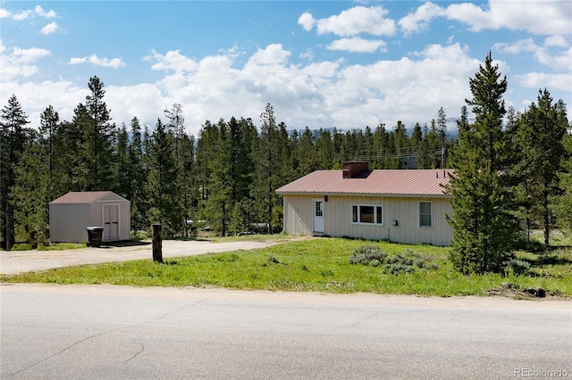 23976 County Rd 50, Fraser, CO 80442 - ranch-style home with metal roof, a forest view, and a chimney
