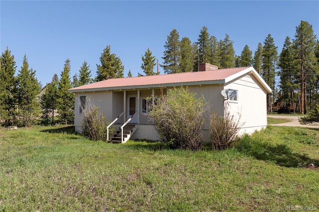 23976 County Rd 50, Fraser, CO 80442 - ranch-style home with a front yard, metal roof, a chimney, and entry steps