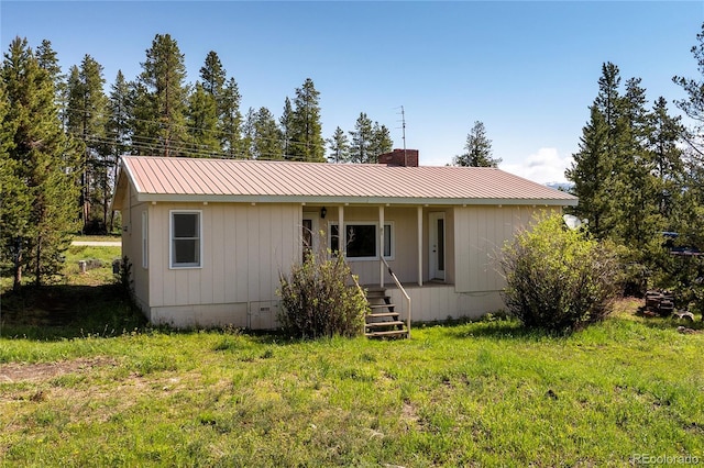23976 County Rd 50, Fraser, CO 80442 - view of front of home featuring covered porch, metal roof, and a chimney