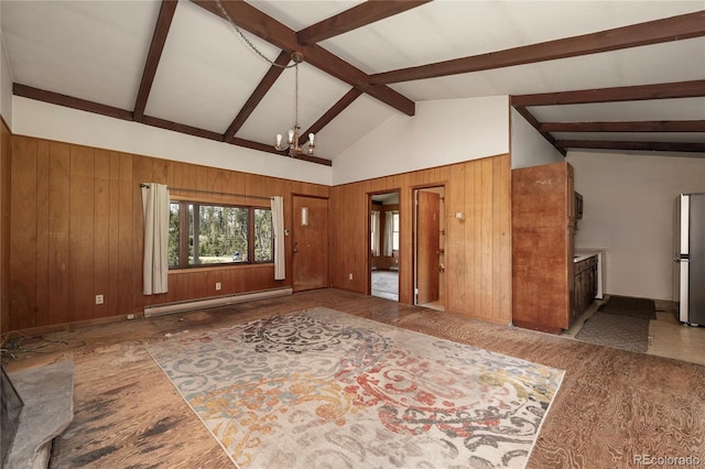 23976 County Rd 50, Fraser, CO 80442 - unfurnished living room with baseboard heating, wood walls, a chandelier, beam ceiling, and baseboards