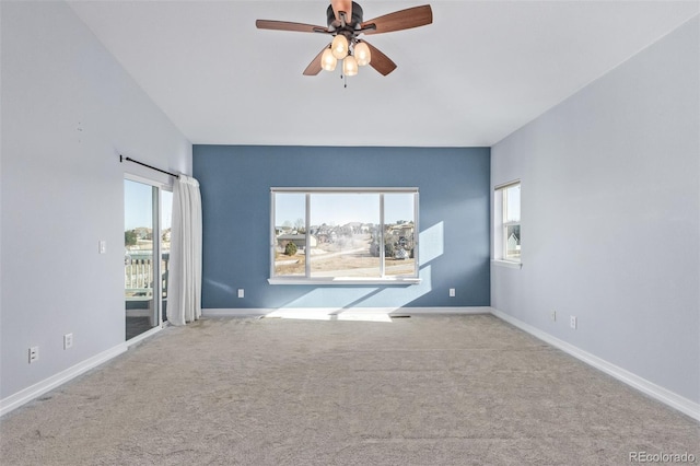 spare room featuring light carpet, plenty of natural light, and baseboards