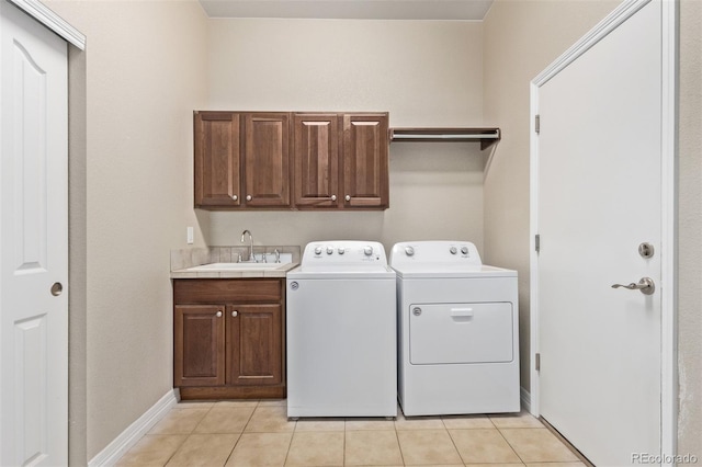 washroom with light tile patterned floors, cabinet space, a sink, independent washer and dryer, and baseboards