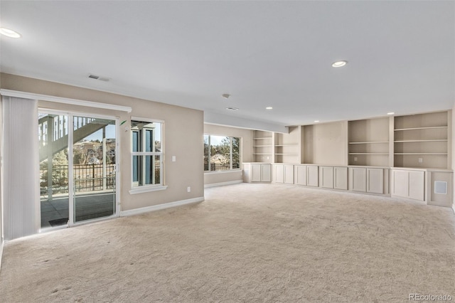 carpeted spare room featuring plenty of natural light, visible vents, baseboards, and recessed lighting