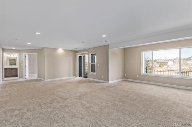 spare room featuring baseboards, recessed lighting, and light colored carpet