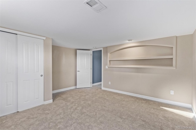 unfurnished bedroom featuring carpet floors, baseboards, visible vents, and a closet