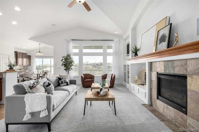 carpeted living room featuring vaulted ceiling, a fireplace, ceiling fan, and recessed lighting
