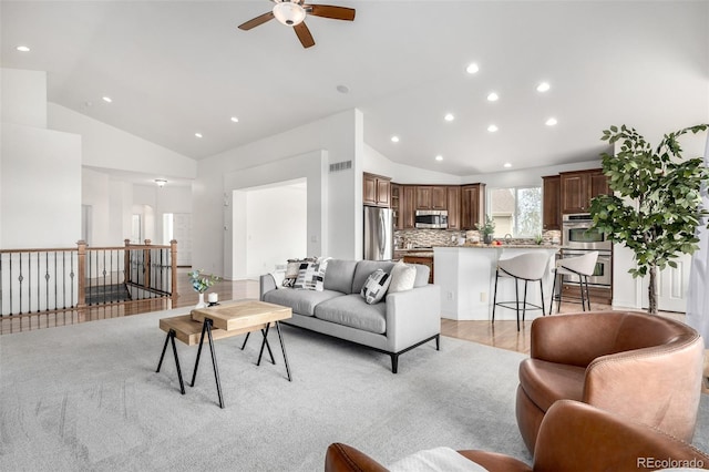 living area featuring vaulted ceiling, ceiling fan, and recessed lighting