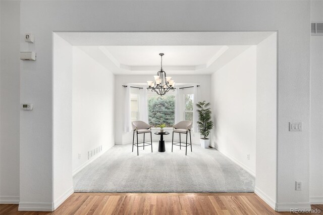 8802 E 148th Ln, Thornton, CO 80602 - dining area with a tray ceiling, wood finished floors, and a chandelier