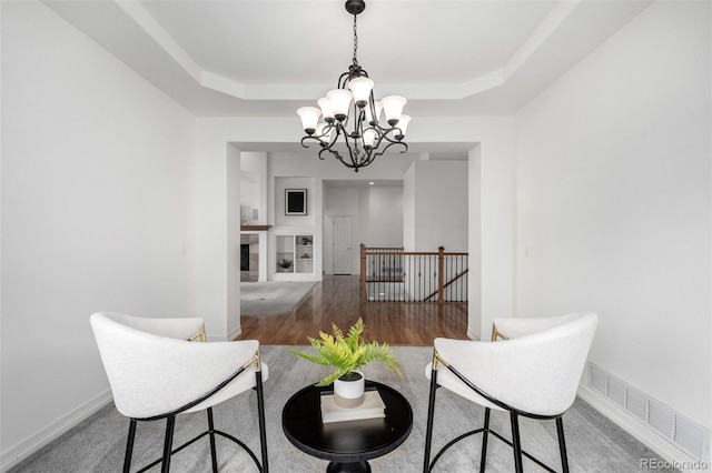 8802 E 148th Ln, Thornton, CO 80602 - living room featuring a chandelier, a raised ceiling, and wood finished floors