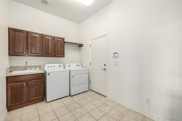 8802 E 148th Ln, Thornton, CO 80602 - laundry room featuring washing machine and clothes dryer, cabinet space, and light tile patterned floors