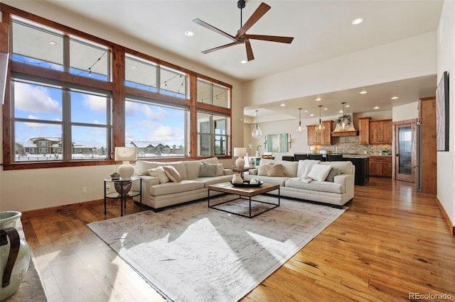 living room featuring wood-type flooring, a wealth of natural light, and ceiling fan